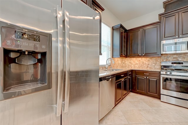 kitchen with decorative backsplash, light stone countertops, stainless steel appliances, sink, and light tile patterned flooring