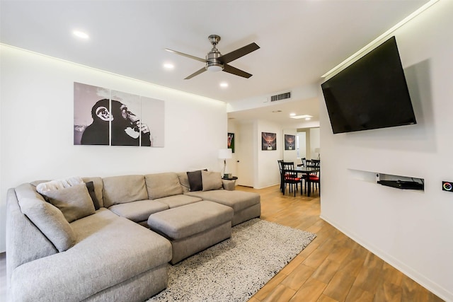 living room featuring ceiling fan and light hardwood / wood-style floors