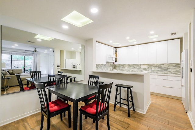 dining room with ceiling fan and light hardwood / wood-style flooring