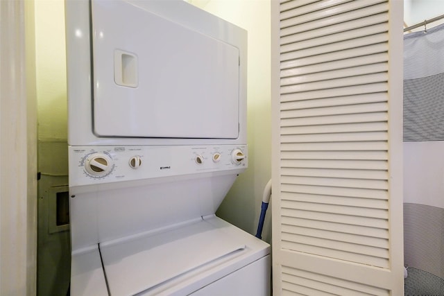 washroom with stacked washing maching and dryer