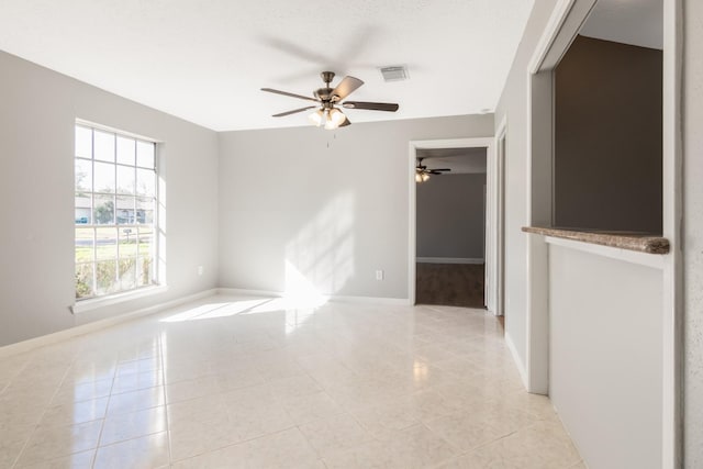 tiled empty room with ceiling fan