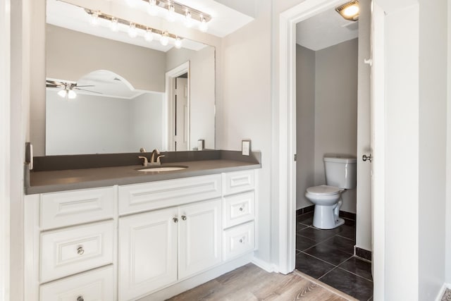 bathroom with tile patterned flooring, ceiling fan, toilet, and vanity