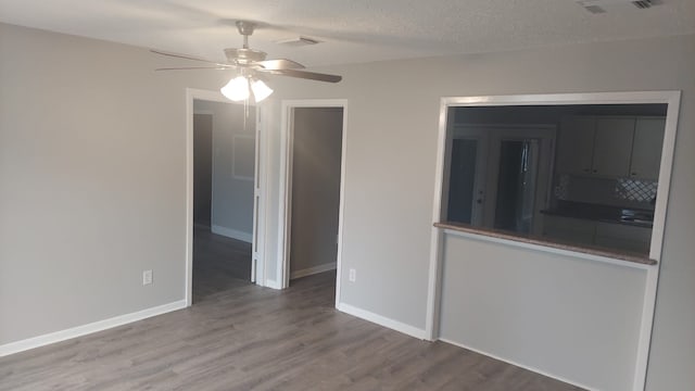 empty room with wood-type flooring, a textured ceiling, and ceiling fan