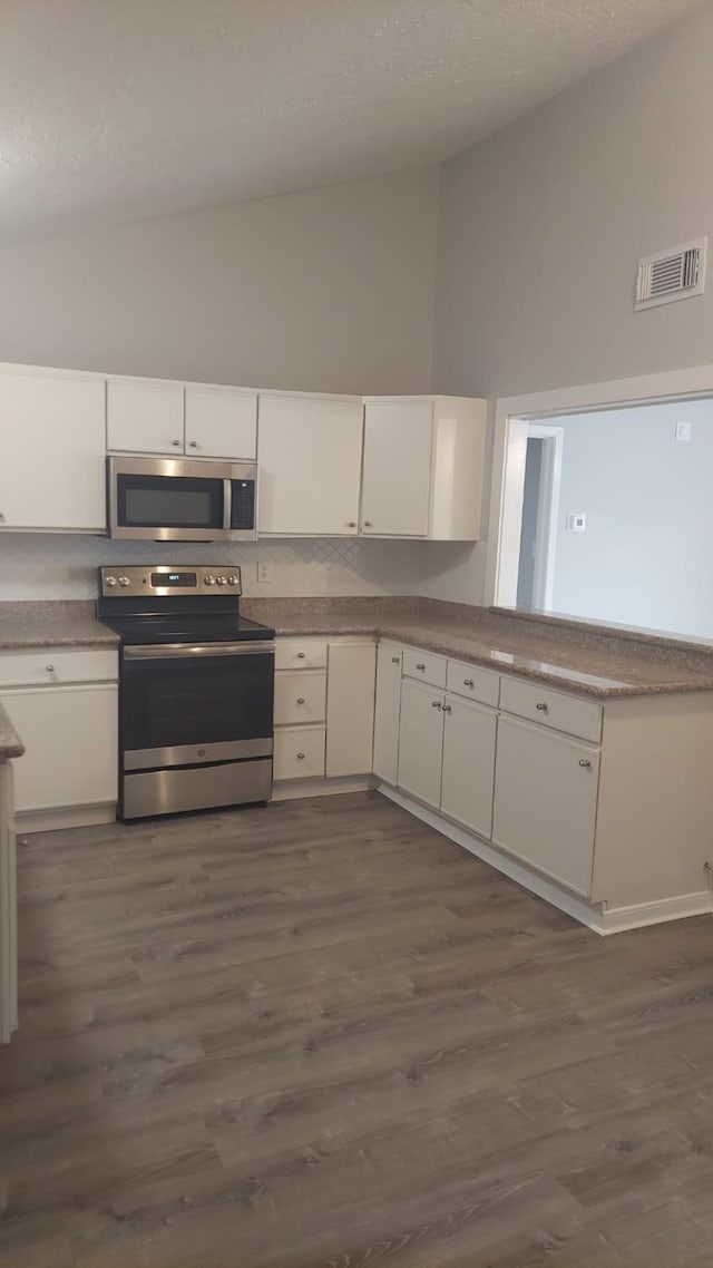 kitchen with dark hardwood / wood-style flooring, white cabinets, and stainless steel appliances