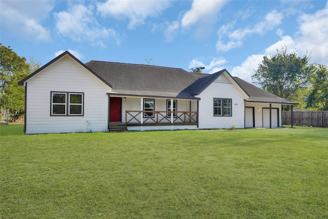 back of property with a lawn, a garage, and covered porch