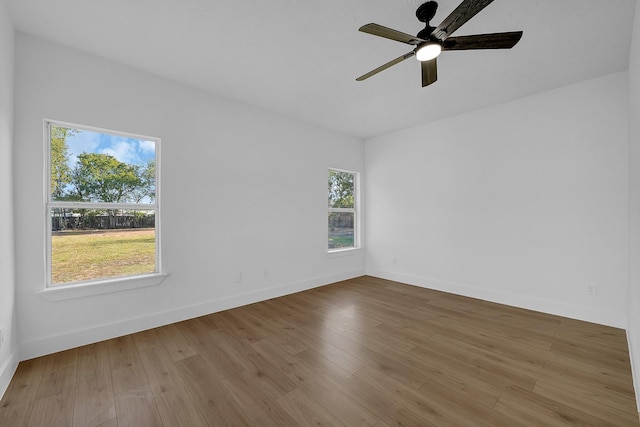 spare room featuring a wealth of natural light, light hardwood / wood-style flooring, and ceiling fan