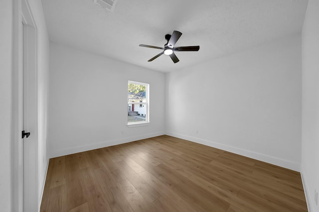 empty room with hardwood / wood-style floors and a textured ceiling