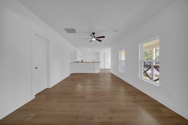 unfurnished living room with ceiling fan and hardwood / wood-style floors