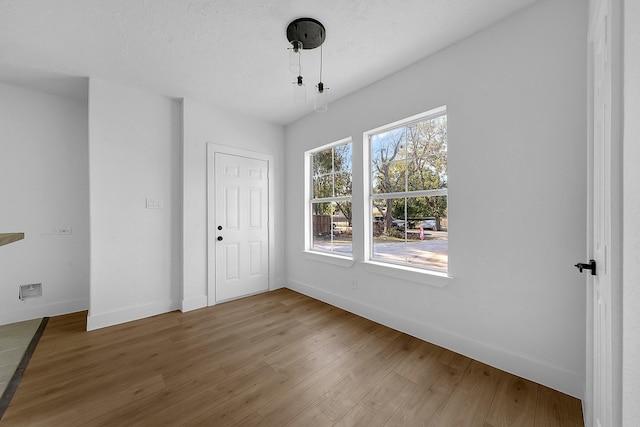 empty room with wood-type flooring and a textured ceiling