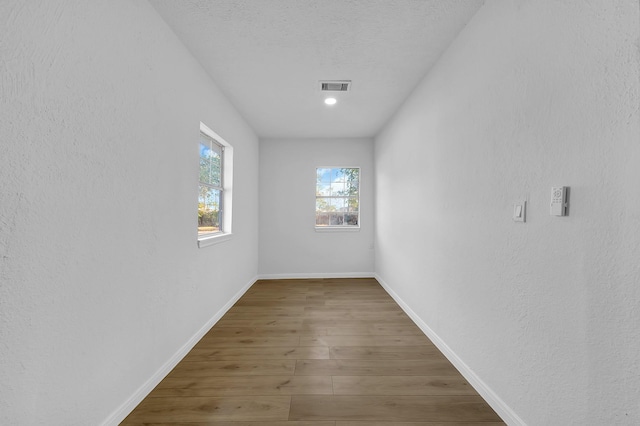 empty room with a textured ceiling and dark wood-type flooring