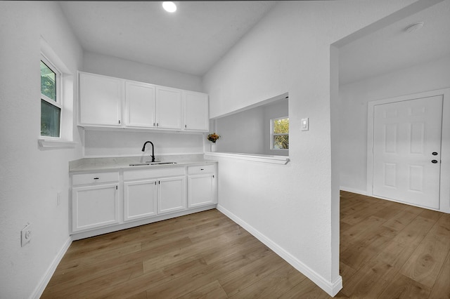 kitchen with plenty of natural light, sink, and light hardwood / wood-style flooring