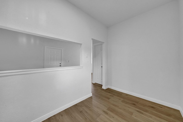 unfurnished room featuring light hardwood / wood-style flooring and lofted ceiling