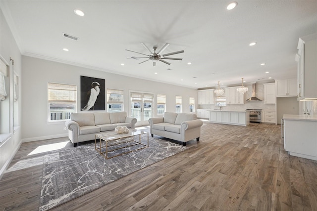 living room with ceiling fan, sink, wood-type flooring, and ornamental molding