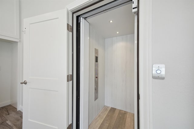 hallway featuring hardwood / wood-style floors and elevator