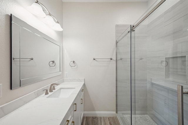 bathroom with vanity, a shower with shower door, and wood-type flooring