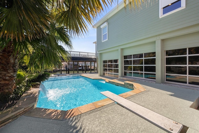 view of pool with pool water feature and a patio