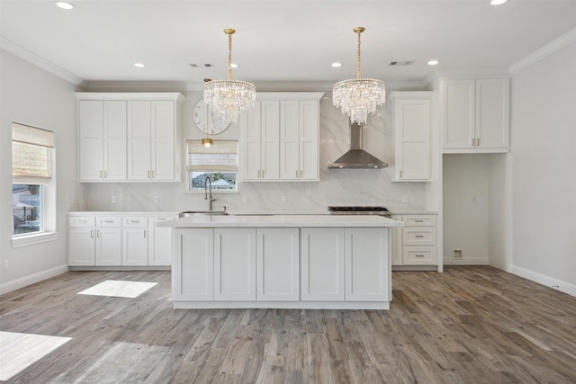 kitchen with white cabinets, decorative light fixtures, and light hardwood / wood-style floors