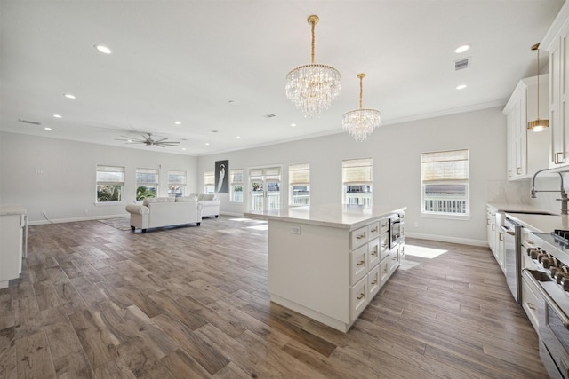 kitchen featuring hanging light fixtures, white cabinets, a healthy amount of sunlight, and a kitchen island