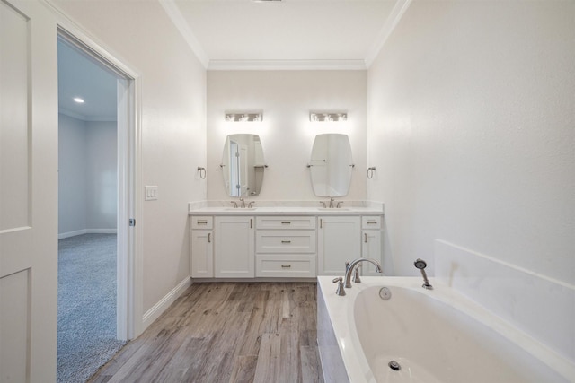 bathroom with hardwood / wood-style floors, vanity, a tub to relax in, and crown molding