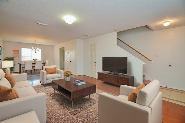 living room with hardwood / wood-style floors and an inviting chandelier