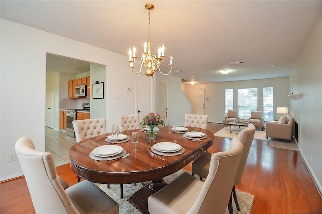 dining space with a chandelier and wood-type flooring