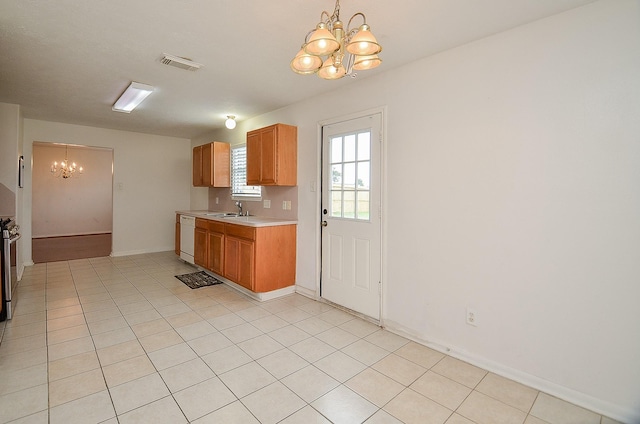 kitchen with dishwasher, light tile patterned flooring, a chandelier, and sink