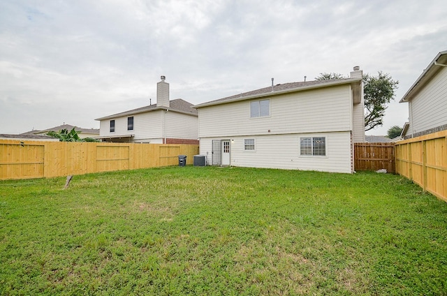 rear view of property featuring a lawn and central AC