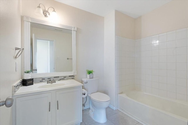 full bathroom with tile patterned floors, tiled shower / bath, vanity, and toilet