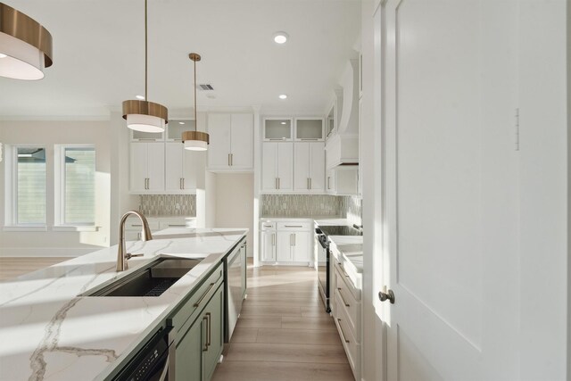 kitchen featuring backsplash, stainless steel appliances, sink, white cabinets, and hanging light fixtures