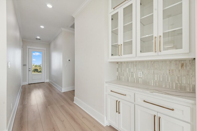 interior space featuring ornamental molding and light wood-type flooring