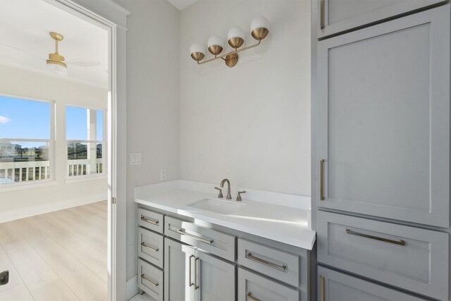 bathroom featuring vanity, ceiling fan, and wood-type flooring