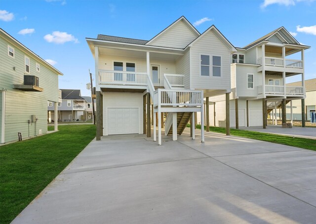 beach home featuring a front lawn, a porch, and a garage