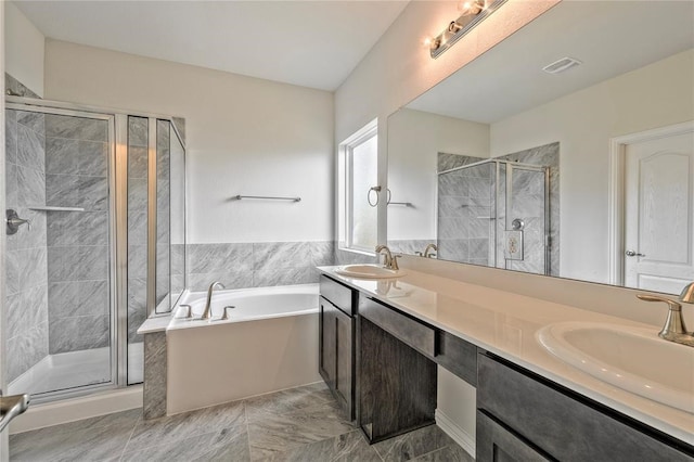 bathroom with vanity and shower with separate bathtub