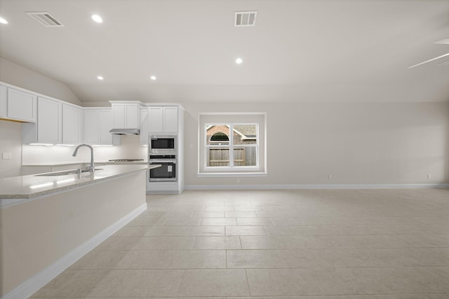 kitchen with stainless steel appliances, a sink, visible vents, white cabinetry, and light stone countertops