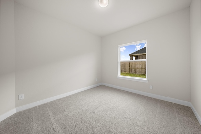 unfurnished room featuring carpet and baseboards