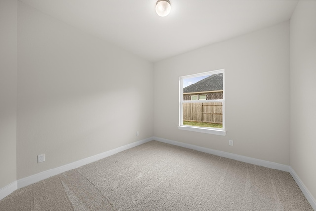 unfurnished room with carpet flooring and baseboards