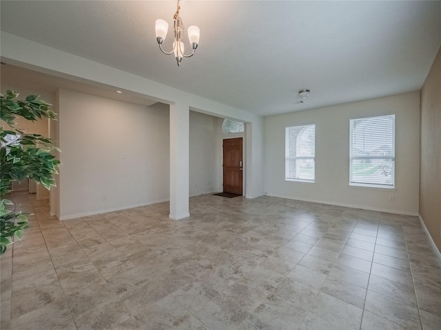 unfurnished room with a chandelier