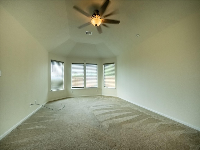 spare room with ceiling fan, light colored carpet, and vaulted ceiling