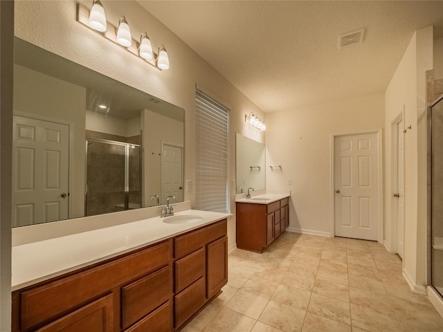 bathroom with tile patterned flooring, vanity, and an enclosed shower