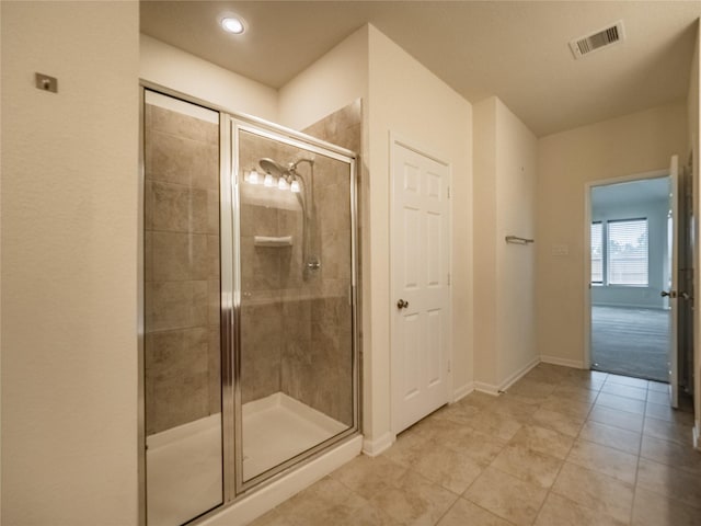 bathroom with tile patterned flooring and a shower with shower door