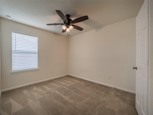 carpeted spare room featuring a textured ceiling and ceiling fan