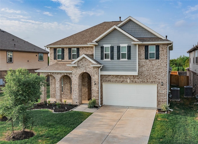 craftsman-style house with a front yard, a garage, and central air condition unit