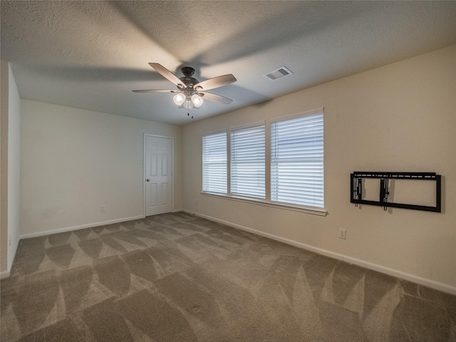 carpeted spare room with ceiling fan and a textured ceiling