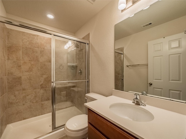 bathroom with toilet, an enclosed shower, a textured ceiling, and vanity