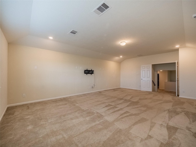 carpeted empty room featuring lofted ceiling