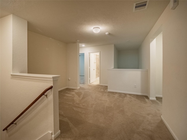 hallway featuring carpet floors and a textured ceiling