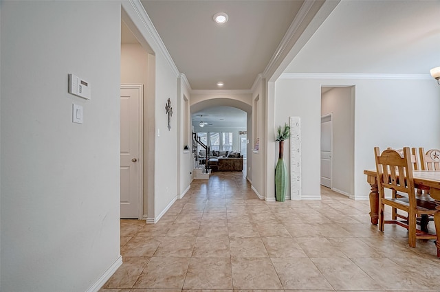 hall with light tile patterned floors and crown molding