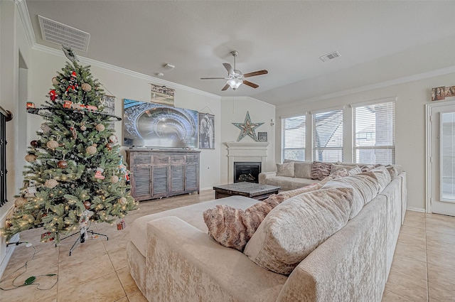 living room with ceiling fan, ornamental molding, light tile patterned floors, and vaulted ceiling