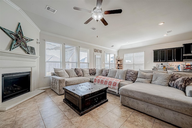 tiled living room with ceiling fan, lofted ceiling, and crown molding