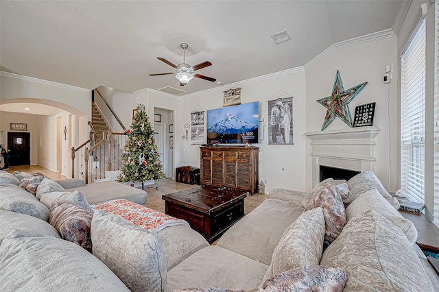 living room with ceiling fan and ornamental molding